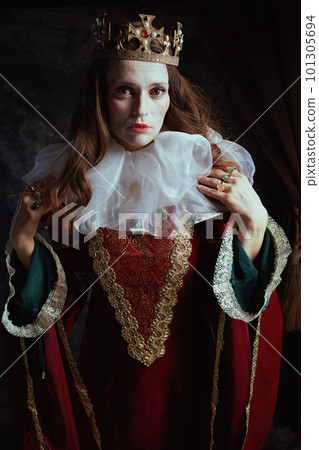 medieval queen in red dress with white collar and crown 101305694