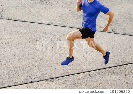 slim muscular male runner running concrete road, top view jogging man in training 101306230