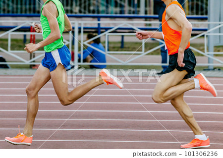 two runners athletes on middle distance run track of stadium, bright running sports clothing, summer athletics championship 101306236