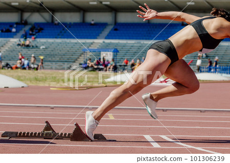 female sprinter start from starting blocks running on stadium track, summer athletics championship 101306239