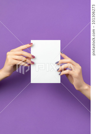 Beautiful womans hand with manicure holding postcard 101306273