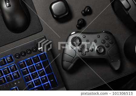 Top view of various modern gaming devices with blue lit keyboard 101306513