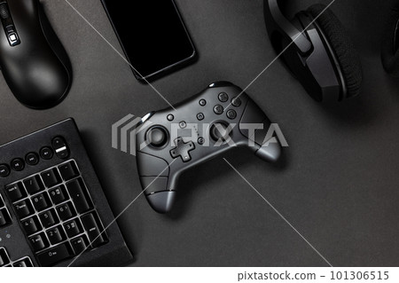 Top view of game controller with gadgets and mobile phone on black gamer desk Top view of game controller with gadgets and mobile phone on black gamer desk 101306515