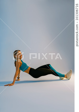 Smiling Fit Woman standing in plank position on studio background. Healthy Lifestyle Concept 101306716