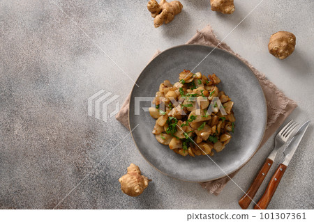 Roasted Jerusalem artichoke root, sunchokes on dark brown. Roasted Jerusalem artichoke root, sunchokes on dark brown. 101307361