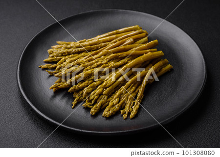 Sprigs of delicious canned asparagus on a black ceramic plate Sprigs of delicious canned asparagus on a black ceramic plate 101308080