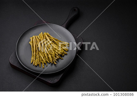 Sprigs of delicious canned asparagus on a black ceramic plate Sprigs of delicious canned asparagus on a black ceramic plate 101308086
