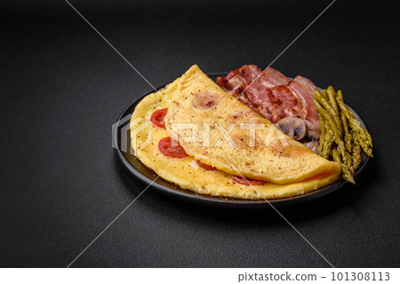 Delicious fresh omelet with cherry tomatoes, bacon, asparagus and spices 101308113