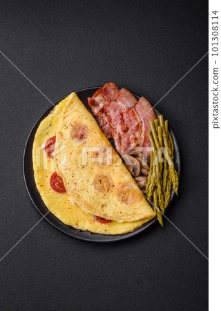 Delicious fresh omelet with cherry tomatoes, bacon, asparagus and spices 101308114