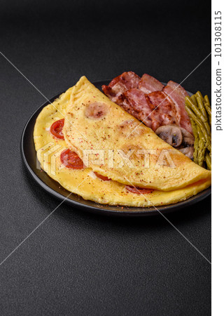 Delicious fresh omelet with cherry tomatoes, bacon, asparagus and spices 101308115
