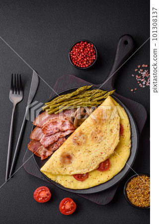 Delicious fresh omelet with cherry tomatoes, bacon, asparagus and spices 101308137