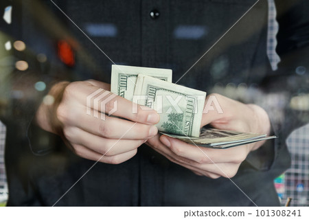 A counts dollars closeup on a blurred background. 101308241