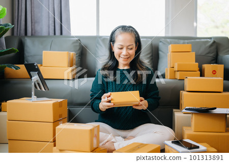 Startup small business SME, Senior woman hand using smartphone or tablet taking receive and checking online purchase shopping order to preparing pack product box. business online shopping concept 101313891