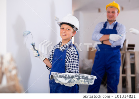 Boy painting wall, renovating home with father 101314821