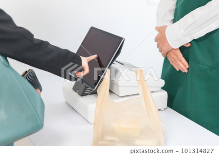A woman's hand operating a touch panel at a convenience store's semi-self checkout A woman's hand operating a touch panel at a convenience store's semi-self checkout 101314827