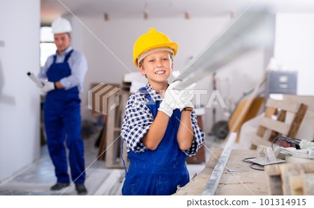 Preteen boy with father carrying building materials Preteen boy with father carrying building materials 101314915