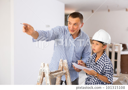 Father with little son talking about repair work in the apartment 101315108