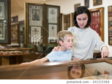 Woman and boy exploring artworks in museum 101315368