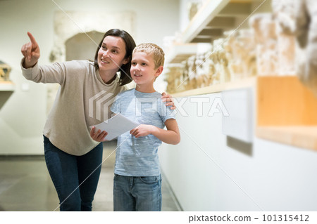 Woman and boy observing sculptures exhibition 101315412