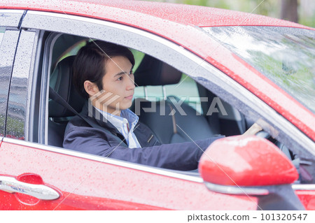 A man driving a car on a rainy day A man driving a car on a rainy day 101320547