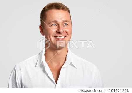 Dremy blue eyed male with positive expression, broad smile, shows white teeth, looks into distance, thinks about something, wears elegant shirt, isolated over white background with blank space Dremy blue eyed male with positive expression, broad smile, shows white teeth, looks into distance, thinks about something, wears elegant shirt, isolated over white background with blank space 101321218