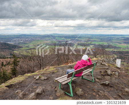 Woman on bench at Lusitian peak in pink warm jacket Woman on bench at Lusitian peak in pink warm jacket 101321639
