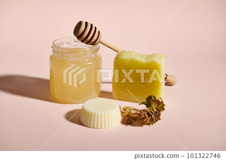 Honey spa concept. Still life with homemade natural cosmetics for skin, body and hair care med from honey and hop cones ingredients, isolated over pink background. Beauty therapy. Purity and hygiene Honey spa concept. Still life with homemade natural cosmetics for skin, body and hair care med from honey and hop cones ingredients, isolated over pink background. Beauty therapy. Purity and hygiene 101322746