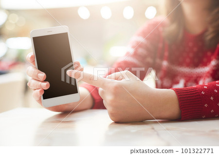 People, technology and advertising concept. Female holds cell phone, indicates at blank copy screen for your promotional text or advertisment, searches internet, spends free time at cafe or home 101322771