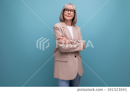 a mature woman with gray hair in a jacket stands confidently against a bright background with copy a mature woman with gray hair in a jacket stands confidently against a bright background with copy 101323041
