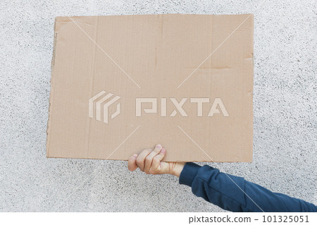 Front view of human holding carton placard with space for inscription, stop racism strike, protesting for defund police, hand with banner against white background. 101325051