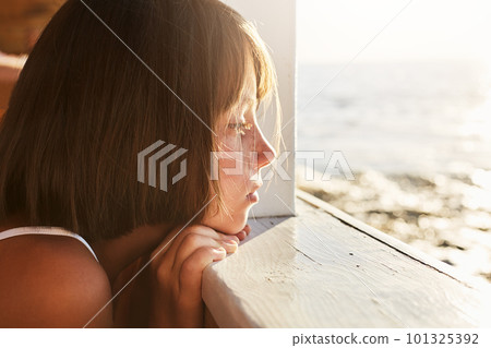 People, children, relaxation, calmness concept. Adorable kid leaning at wooden deck, looking ar sea landscapes with dreamy expression, thinking about something pleasant. Ship cruise and adventure People, children, relaxation, calmness concept. Adorable kid leaning at wooden deck, looking ar sea landscapes with dreamy expression, thinking about something pleasant. Ship cruise and adventure 101325392