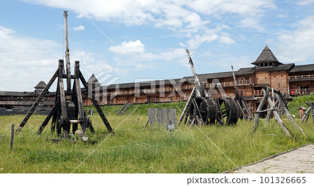 Kiev, Ukraine June 19, 2021: Ancient catapult in the entertainment complex Kievan Rus, an old wooden fortress and artists doing a performance. 101326665