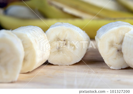 a ripe sweet banana cut into pieces lies on the table 101327200