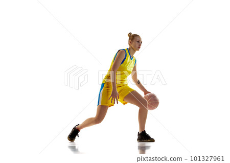 Game on. Young girl in yellow uniform, basketball player in motion, training against white studio background. Concept of professional sport Game on. Young girl in yellow uniform, basketball player in motion, training against white studio background. Concept of professional sport 101327961