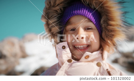 Close-up portrait of a beautiful little girl wearing warm clothes in snowy mountains in winter Close-up portrait of a beautiful little girl wearing warm clothes in snowy mountains in winter 101328002