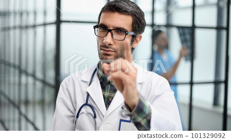 attentive doctor in white coat pointing his finger at you attentive doctor in white coat pointing his finger at you 101329092