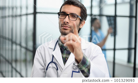 attentive doctor in white coat pointing his finger at you attentive doctor in white coat pointing his finger at you 101329093