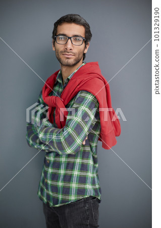 Male beauty. Portrait of a handsome young man with dark hair in glasses on a gray background. Male beauty. Portrait of a handsome young man with dark hair in glasses on a gray background. 101329190