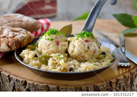 Delicious South Tyrolean bacon dumplings served on sauerkraut in an iron frying pan Delicious South Tyrolean bacon dumplings served on sauerkraut in an iron frying pan 101332227