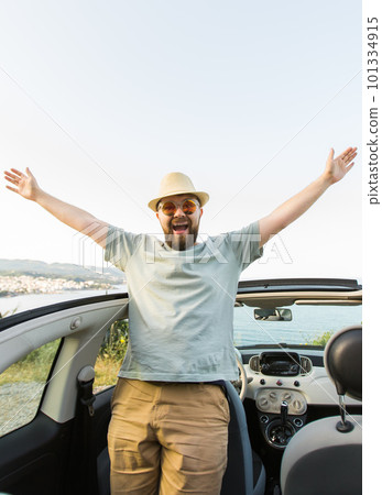 Happy man sitting in white convertible car with beautiful view and having fun - travel summer vacation and rental car concept 101334915