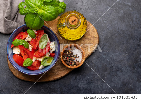 Caprese salad with ripe tomatoes, mozzarella cheese and garden basil 101335435
