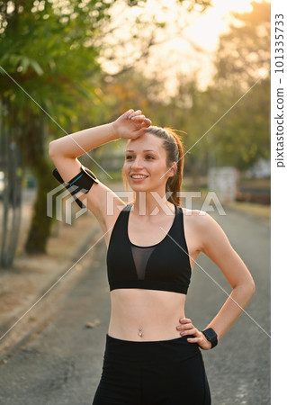 Portrait of beautiful sportswoman taking a break during outdoor. Healthy lifestyle and sports concept Portrait of beautiful sportswoman taking a break during outdoor. Healthy lifestyle and sports concept 101335733