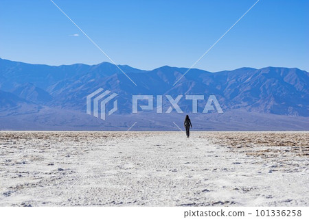 Sunny view of a woman walking in Badwater Basin 101336258