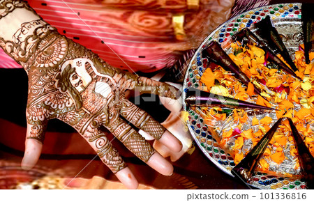 Beautiful artwork drawn on the hand of an Indian bride with herbal heena in wet condition. Beautiful artwork drawn on the hand of an Indian bride with herbal heena in wet condition. 101336816