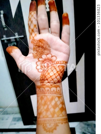 Beautiful artwork drawn on the hand of an Indian bride with herbal heena in wet condition. Beautiful artwork drawn on the hand of an Indian bride with herbal heena in wet condition. 101336823