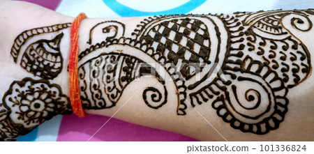 Beautiful artwork drawn on the hand of an Indian bride with herbal heena in wet condition. Beautiful artwork drawn on the hand of an Indian bride with herbal heena in wet condition. 101336824