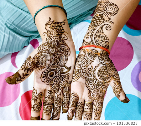 Beautiful artwork drawn on the hand of an Indian bride with herbal heena in wet condition. 101336825