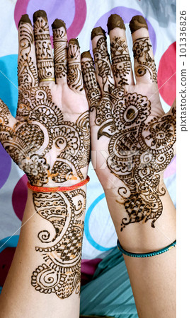 Beautiful artwork drawn on the hand of an Indian bride with herbal heena in wet condition. Beautiful artwork drawn on the hand of an Indian bride with herbal heena in wet condition. 101336826
