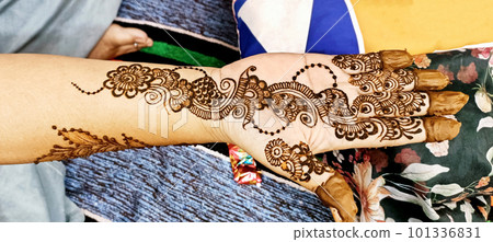 Beautiful artwork drawn on the hand of an Indian bride with herbal heena in wet condition. Beautiful artwork drawn on the hand of an Indian bride with herbal heena in wet condition. 101336831