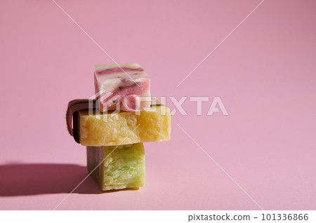 Stack of homemade natural eco soap bars with organic herbal and floral ingredients for health and spa, isolated on pink background. Purity. Hygiene. Skin and body care concept 101336866